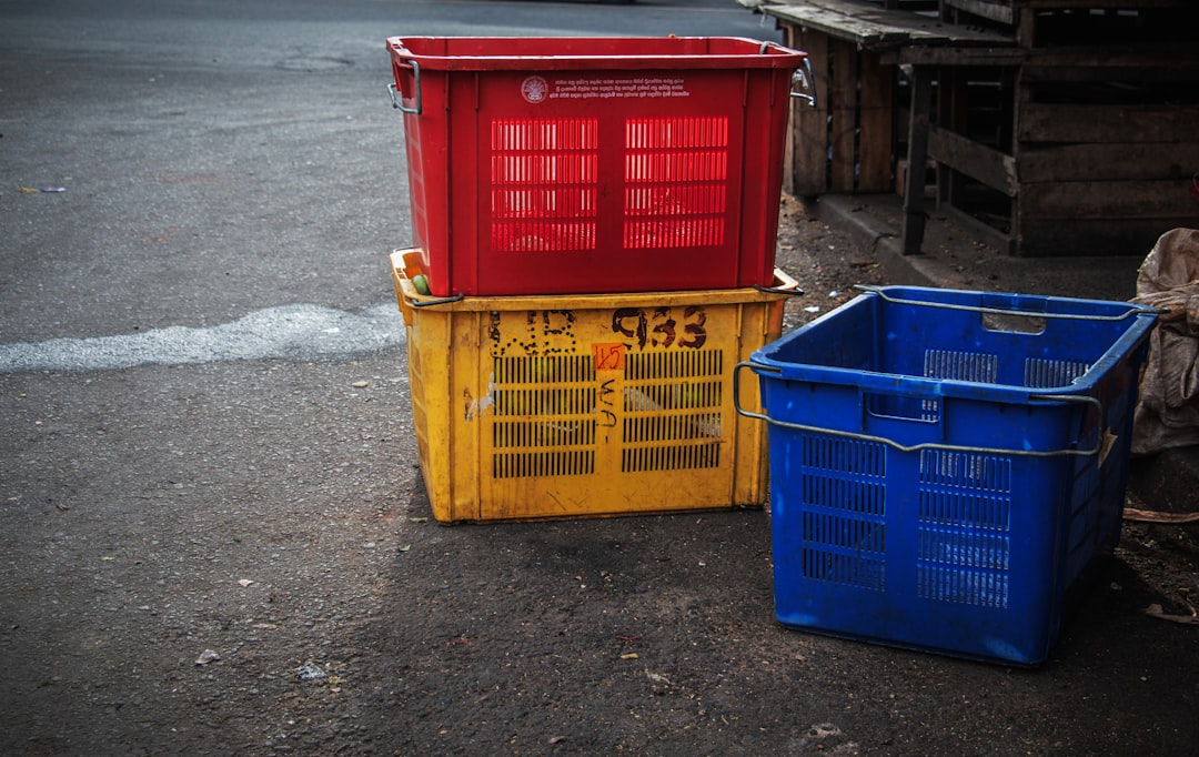 services-01 three-colorful-plastic-crates-stacked-on-pavement-uxj5sqmk-ug